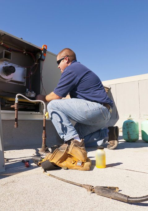 HVAC Tech on Roof top working on Cooling System